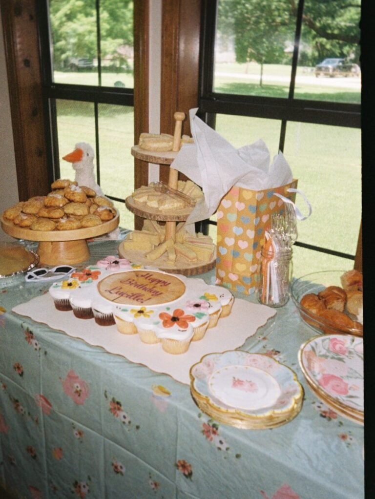 Celebration table with cupcakes, cookies, and a gift bag